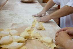 Bakers shaping bread rolls by hand