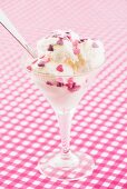 Vanilla ice cream with pink and purple sugar hearts in a sundae glass