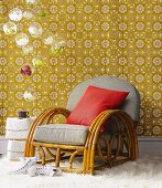 Art Deco rattan chair in front of vintage floral wallpaper and hanging glass balls with orchid flowers