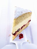 A slice of cream cheese layer cake with cherries