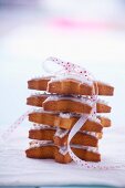 Pile of gingerbread stars garnished with icing and tied with ribbon