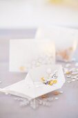 Envelopes of gold and silver sequins as table decorations