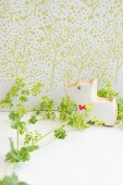 A dog-shaped biscuit with lady's mantle against a light green patterned wall