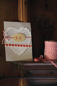 Hand-crafted Christmas card with heart-shaped paper doily