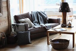 Modern, country-house atmosphere in seating are with hand-sewn cushions and blanket on leather sofa