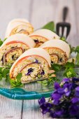 Cheese and ham rolls with egg salad and violets