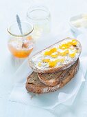 Mixed rye and wheat bread, topped with butter and orange jam
