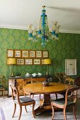 Essplatz mit antiken, englischen Möbeln, Kronleuchter & floral gemusterter Tapete