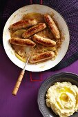 Pork sausages in an apple wine sauce served with mashed potatoes