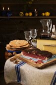 A rustic light meal from South Tyrol, consisting of dry-cured ham, Schüttelbrot (crispy unleavened bread), nuts, cheese and wine