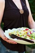 A woman serving a large bowl of potato salad