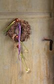 Wreath with flower bulbs and ribbons on vintage front door