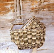 Two hand-woven willow baskets in front of wooden wall