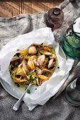 Linguine with clams and Pancetta en papillote on a table laid with maritime decorations