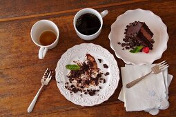 Piece of Chocolate Cake on a Plate; Dirty Plate with Cake Remains; Tea and Coffee