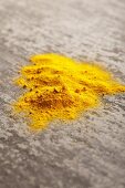 Ground turmeric on a grey surface