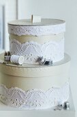 Round storage boxes for sewing kit decorated with white lace ribbon