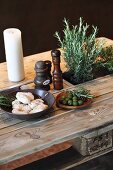 Potted herbs and candle on rustic dining table made from pallet