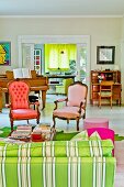 Complementary shades of red and green - Rococo armchairs with modern upholstery, striped sofa and curtain in background