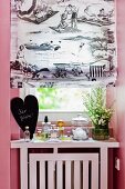 Faltrollo mit schwarzweissem Print an Badezimmerfenster mit Parfumfläschchen für Gäste