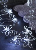 Flowers hand-crafted from long beads decorating string of fairy lights