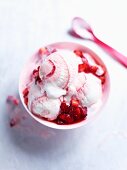 A bowl of strawberry ice cream with fresh strawberries