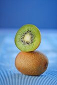 A whole and a half kiwi stacked on on top of the other