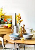 Gedeckter Tisch mit Geschirr, Besteck, Salz- und Pfeffermühle und Blumenvase