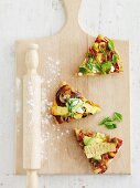 Three pizza slices with different toppings: ham and pineapple; lamb, sweet potato and mushroom; and bean and avocado