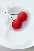 Marzipan cherries with a bow on a plate