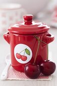 Cherry jam in a red pot with a cherry sticker