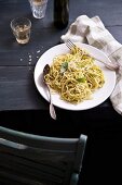 Spaghetti with pesto on a rustic wooden table