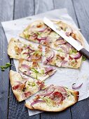 Tarte flambée with onions, spring onions and bacon