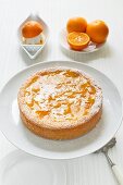 orange cake on a cake stand with fresh oranges