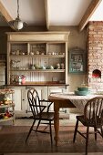 Shaker-style dresser and wooden armchairs in kitchen-dining room of old, renovated dairy in South Africa