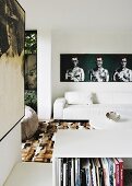 Wohnzimmer mit weißem Ledersofa und modernen Kunstwerken an den Wänden
