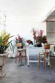 Florists' workbench surrounded by various flowers in simple interior