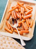 Oven-roasted baby carrots with balsamic vinegar, on the baking tray