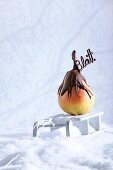 A pear dipped in chocolate, with chocolate writing, at Christmas