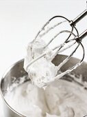 Steif geschlagener Eischnee in Rührschüssel & an Rührstäben