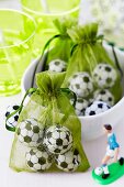 Chocolate footballs packed in green organza bags