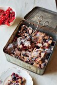 Cinnamon cake with mixed berries, slices in a tin box and on a plate