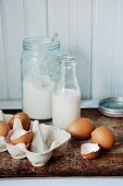 Milk, flour and eggs, some broken open