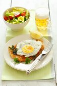 Veal schnitzel with a fried egg, lettuce and beer