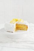 Lemon layer cake on a cake stand, cut to show the centre
