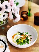 Pea salad with asparagus, courgette flowers, and a carrot & yoghurt sauce