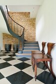 Elegant winding staircase in converted barn with exposed masonry wall
