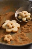 Flower-shaped biscuits on a pewter plate coated with cinnamon