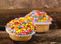 Cupcakes decorated with colourful chocolate beans