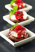 Cupcakes with cream cheese topping, raspberry sauce and grated chocolate